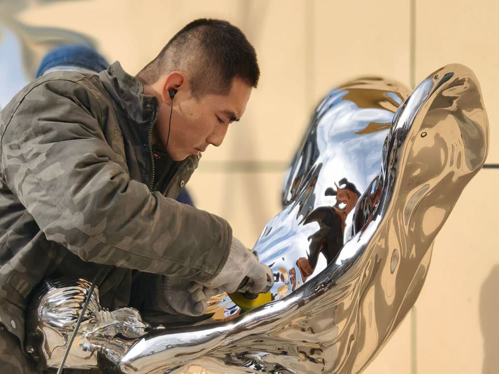 Craftsman hand-polishing stainless steel to 8K mirror finish