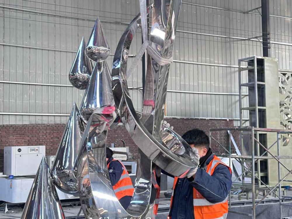 Large-scale metal sculpture assembly in workshop
