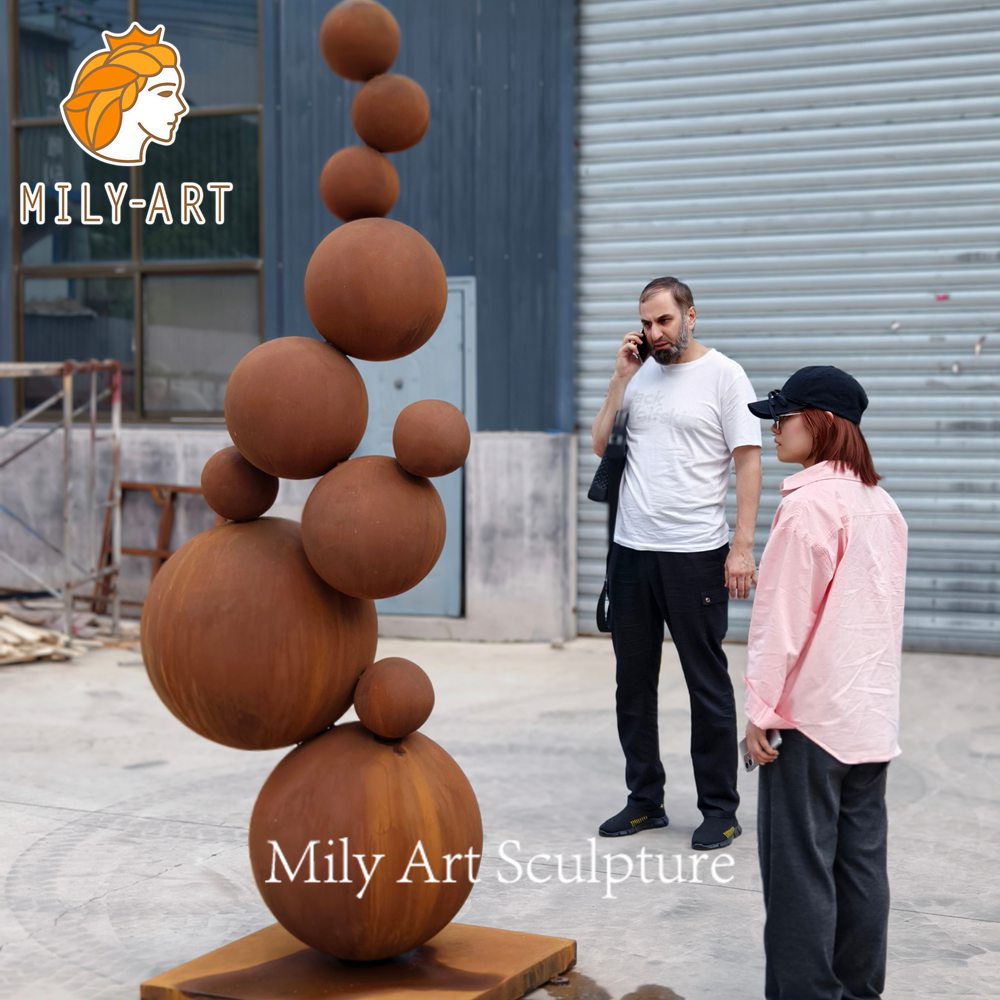 clients visiting mily corten steel ball sculpture